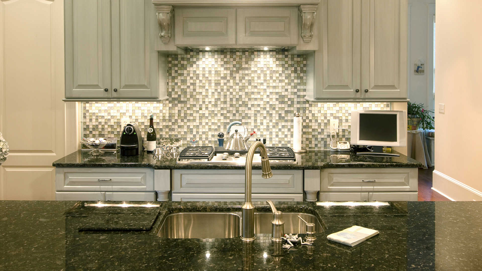 Beautiful kitchen with glass backsplash and clean granite countertop